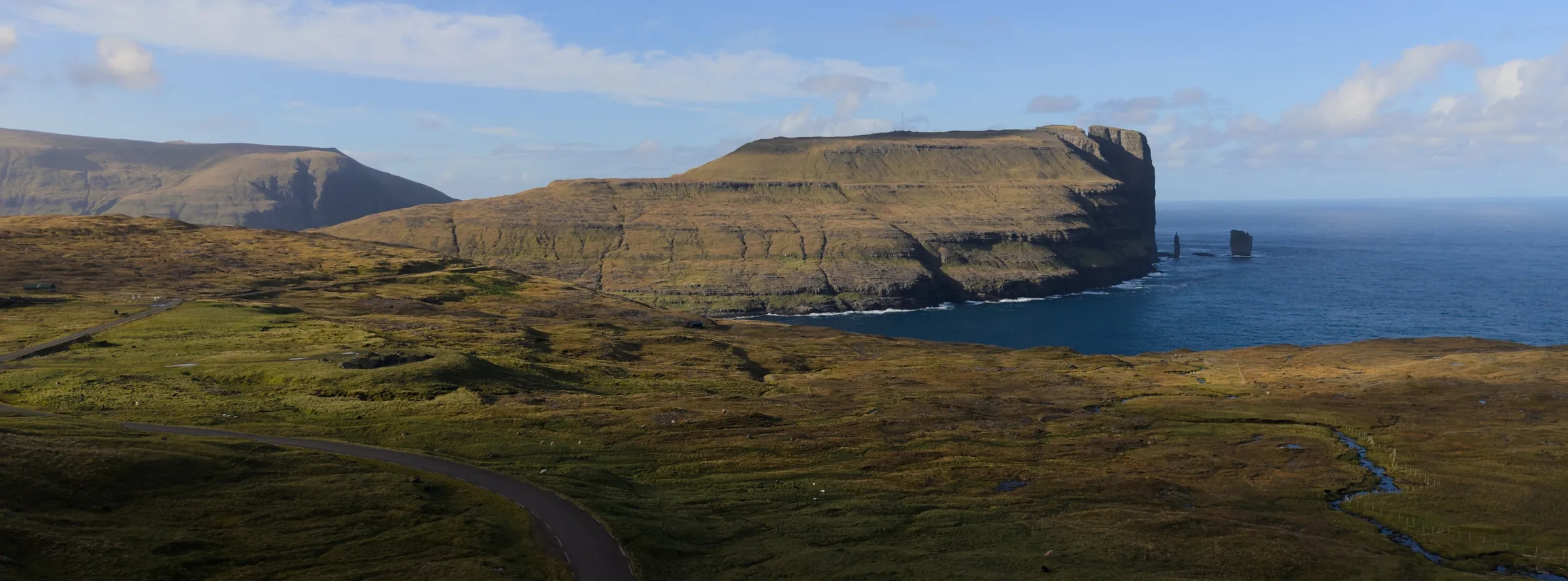 A coastal landscape in the Faroe Islands, with the AppVerge apps in a Dock along the bottom.